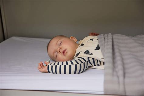Illustratie van een slapende baby met een thermometer om het belang van rust bij ziekte te benadrukken
