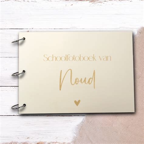 Close-up van een houten cover van een schoolfotoboek met een gegraveerde naam