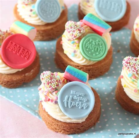 Illustratie van diverse kleine geboortetaartjes en cupcakes met baby-thema decoraties.