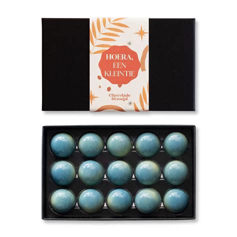 Een luxe chocoladeboek met geboorte bonbons, verpakt in een stijlvolle boekvorm.