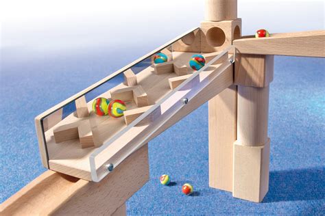 Een compilatie van verschillende Haba speelgoedartikelen, waaronder de Little Friends poppen en een knikkerbaan.