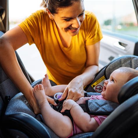 Afbeelding van een ouder die een kind veilig in een autostoeltje plaatst.