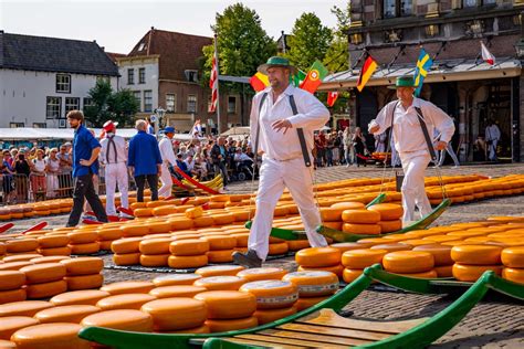 Illustratie van de kaasmarkt in Alkmaar met kaasdragers en het Waaggebouw op de achtergrond.