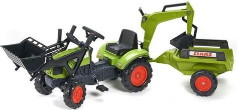 Groene John Deere RollyKid traptractor met aanhanger, gefotografeerd in een buitenomgeving.