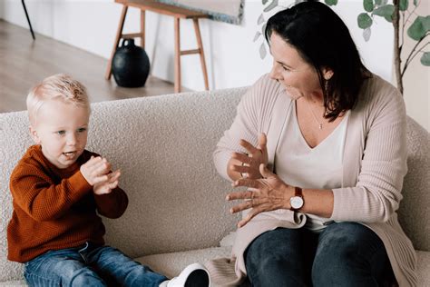 Illustratie van een ouder die met een peuter zingt en gebaren maakt.