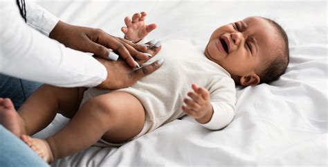 Een baby met gebalde vuistjes en getrokken beentjes, kenmerkend voor krampjes