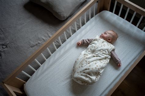 Een baby die veilig en comfortabel ingebakerd slaapt in een speciaal slaapzakje.