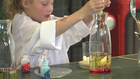 kinderen die enthousiast proefjes doen met een bak water en diverse voorwerpen