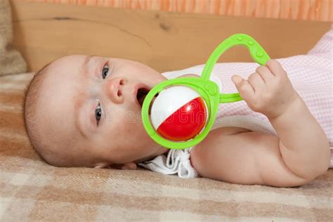 Een baby die speelt met een houten rammelaar