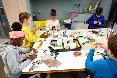 Foto van een moderne buitenschoolse opvangruimte met kinderen die aan tafel knutselen