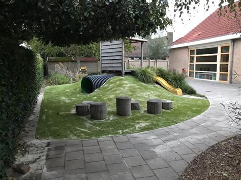 Foto van een kinderdagverblijf met veel groen en natuurlijke speelelementen