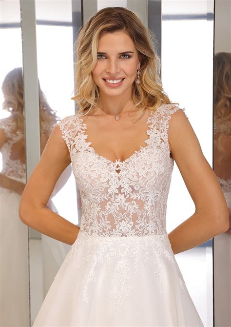 Gedetailleerde foto van een trouwjurk met rijgveter, die de aanpasbaarheid voor een groeiende buik benadrukt.