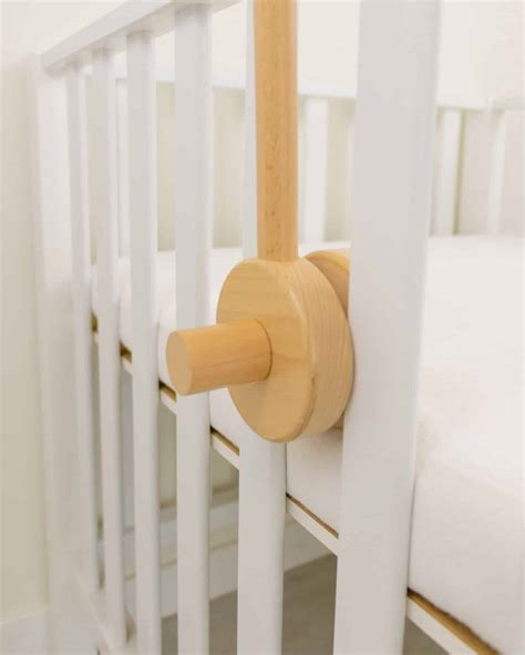 Illustratie van een houten muziekmobiel houder bevestigd aan een babybedje