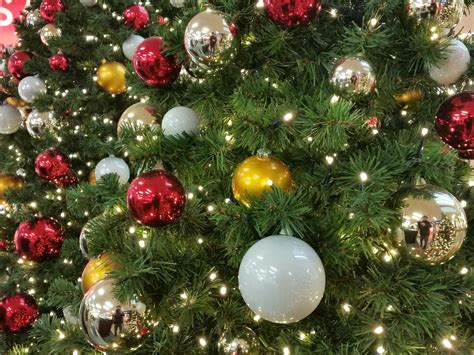 Een feestelijk versierde kerstboom met kerstballen en lichtjes, klaar om ingekleurd te worden.
