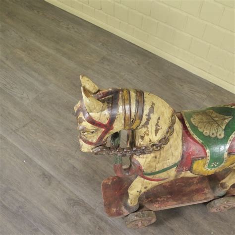 Gedetailleerde foto van een houten paard op wielen met rijke versieringen