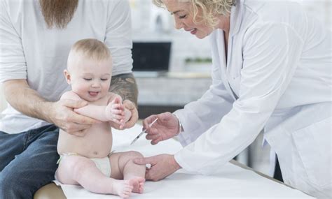 Kinderarts die een baby onderzoekt op een consultatiebureau