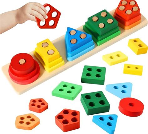 Grimm's houten speelgoed in verschillende kleuren en vormen, met de nadruk op de regenboog en blokken.