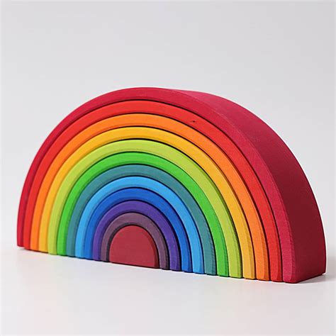 Een kind dat speelt met de Grimm's regenboog, deze stapelend en er een knikkerbaan van makend.