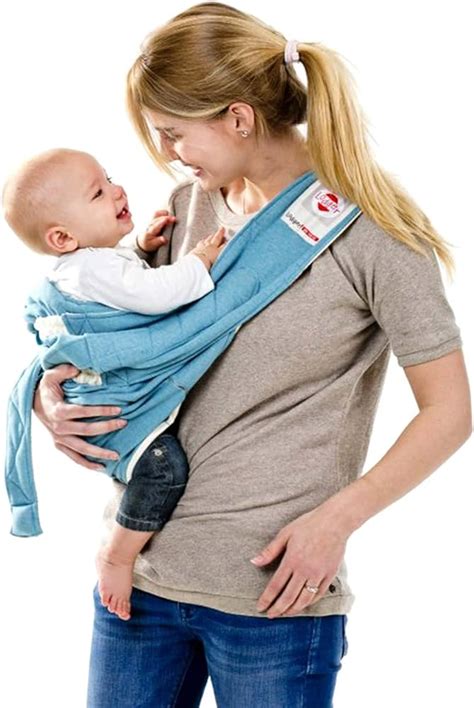 Een baby die comfortabel in een Lodger Shelter 2.0 wordt gedragen, met de focus op het gebruik als inwikkeldeken voor een autostoeltje.