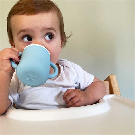 Baby drinkt water uit een beker