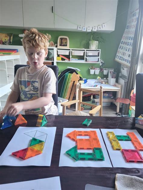 Kind dat geconcentreerd bouwt met magnetische tegels