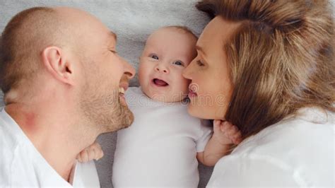 Afbeelding van een gezin met een pasgeboren baby en een trotse grote zus die naar de baby kijkt.