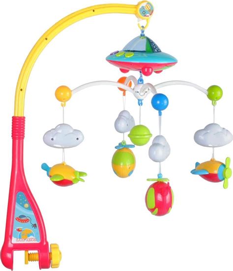 een baby die vanuit de box naar een kleurrijke muziekmobiel kijkt