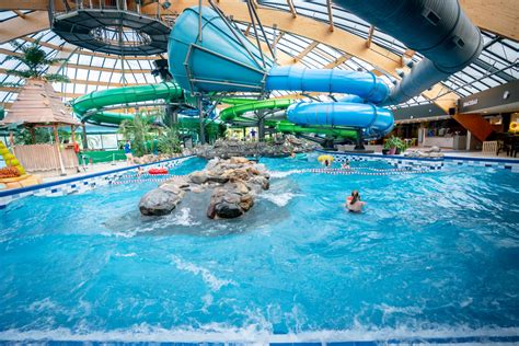 Illustratie van een tropisch zwembad met glijbanen en palmbomen