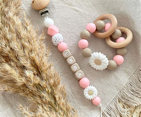 Illustratie van een baby die op een gepersonaliseerde bijtring kauwt.