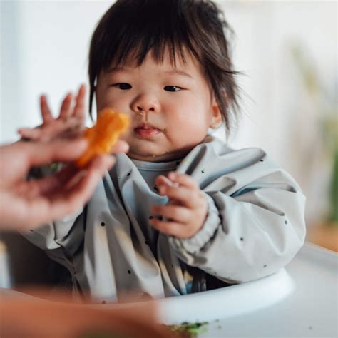 baby die zelf een lepel probeert vast te houden