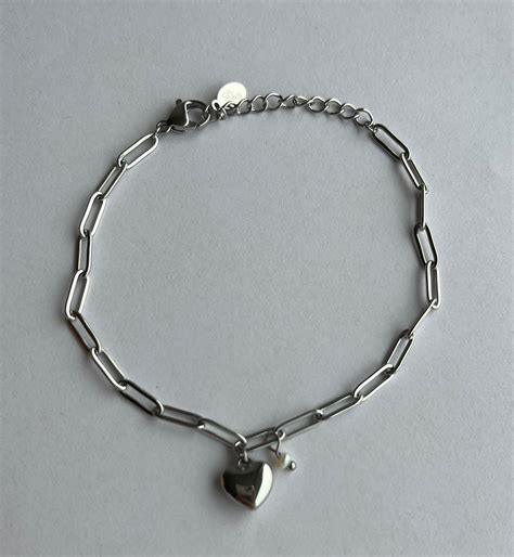 Close-up van een armband met letterkralen en metalen bedeltjes