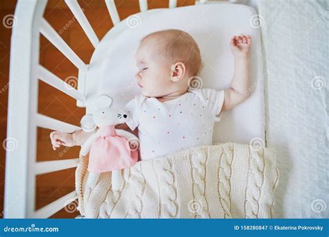 Foto van een baby die slaapt in een bassinet aan de muur van een vliegtuig