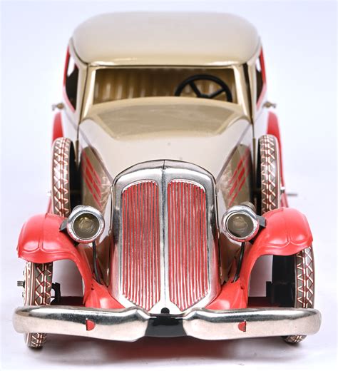 Foto van een moderne reproductie van een klassiek blikken auto, naast een origineel vintage exemplaar.