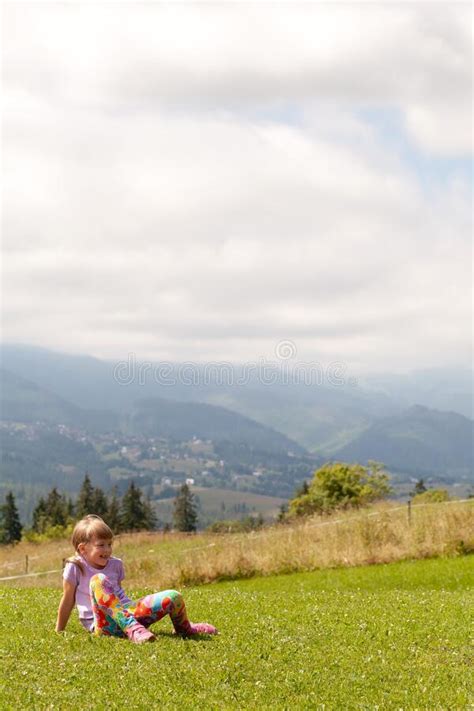 Meisje met kleurrijke peutersandalen die vrolijk rondrent op een grasveld.