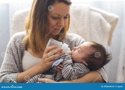 Een intieme lifestyle foto van een moeder die haar baby voedt.
