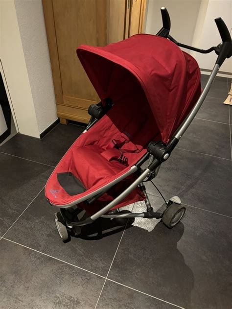 Illustratie van de Quinny Zapp Flex kinderwagen met kindje erin, die flexibel door een stadse omgeving beweegt.