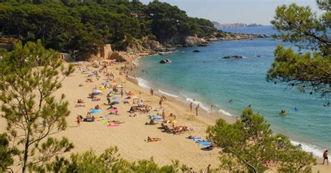 Foto van een schilderachtig baaitje aan de Costa Brava met een gezin op het strand