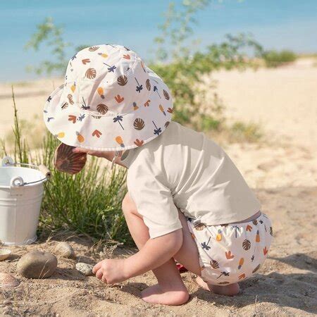 Illustratie van een baby in een zwemluier die vrolijk in het water speelt.