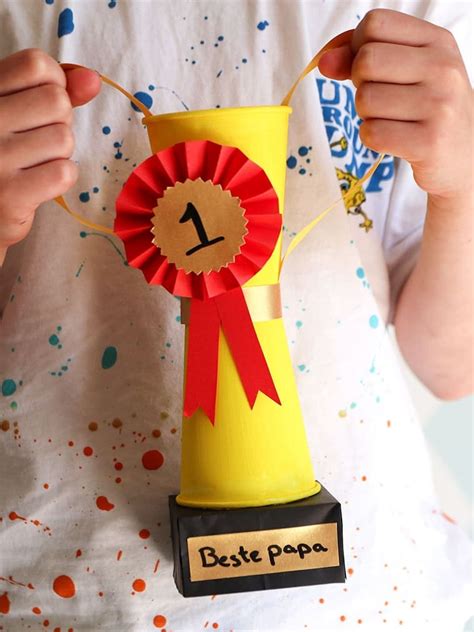 Een kind dat een zelfgemaakte trofee voor Vaderdag vasthoudt.