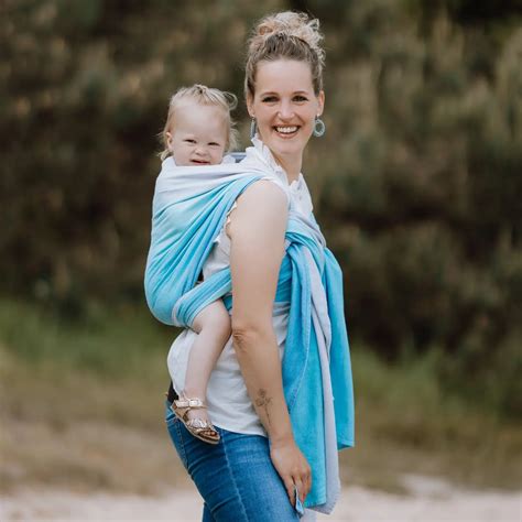 baby die rechtop gedragen wordt in een draagdoek