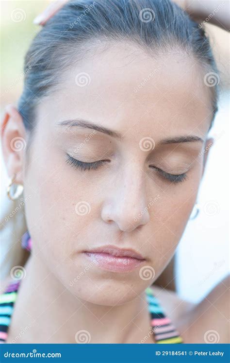 Vrouw die met gesloten ogen pijnlijke gezichtsuitdrukking toont tijdens een medische procedure.