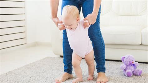een dreumes die probeert te lopen met behulp van een loopwagen
