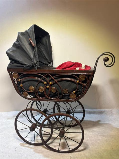 Afbeelding van een moderne kinderwagen naast een antieke poppenwagen, ter contrast.