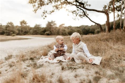 Een baby die voorzichtig een klein fruitijsje likt