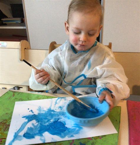 Kinderen verven een bordje als basis voor een gezicht.