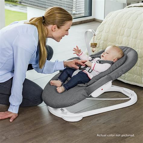 Illustratie van een baby die comfortabel in de Stokke Steps Bouncer ligt, met de mogelijkheid om deze aan de kinderstoel te bevestigen.