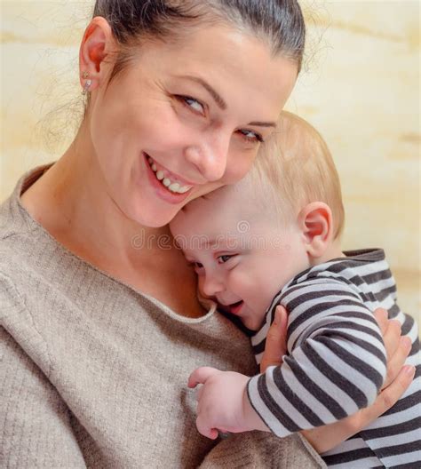 Een foto van een blije, ontspannen moeder met haar pasgeboren baby.