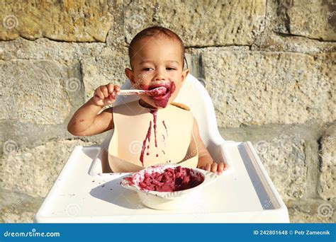 Een infant die in een kinderstoel wordt gevoerd.