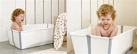 een peuter die voorzichtig speelt in een ondiep badje onder toezicht van een volwassene