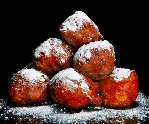 Illustratie van verse, goudbruine oliebollen met poedersuiker.